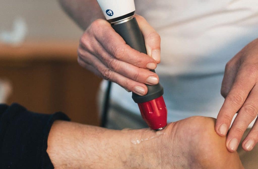 shockwave therapy handpiece delivers acoustic wave into the achilles tendon to promote healing and pain reduction